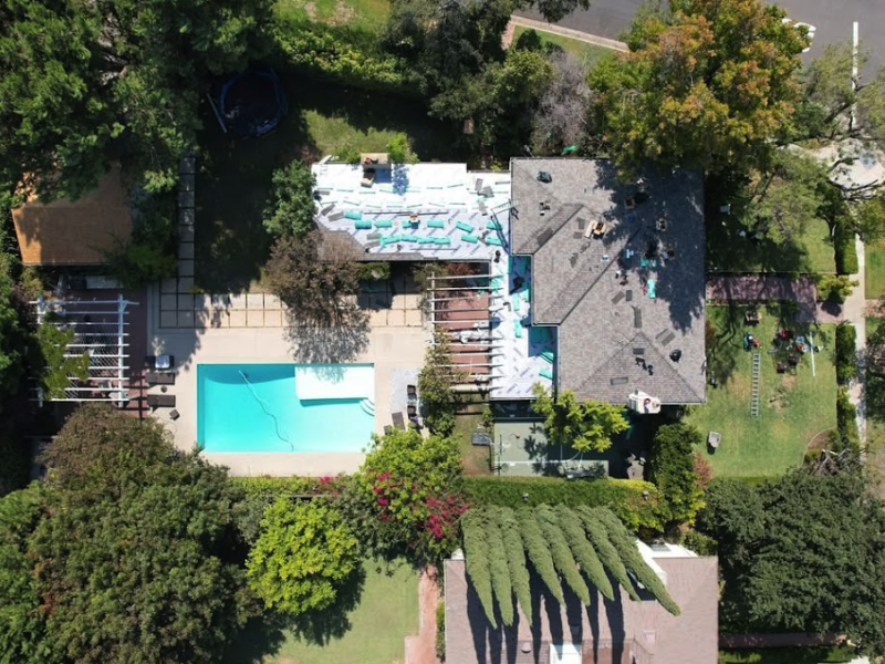 Aerial view of a Green Ladder reroof in progress on a pool estate